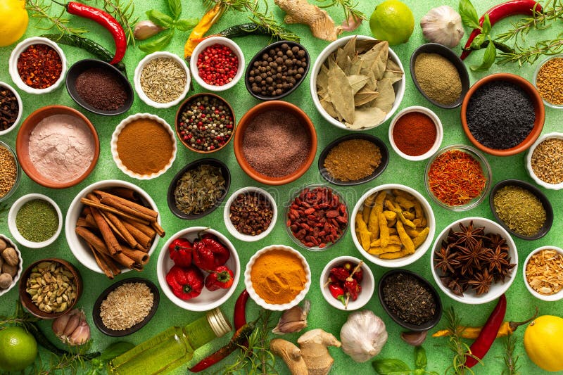 Un assortimento colorato di spezie e erbe fragranti fresche riprodotte su uno sfondo verde morbido che cattura un vibrante fotografie stock libere da diritti