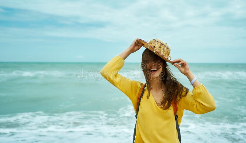 Un'autentica ragazza positiva con un ritratto estivo che tiene in mano la paglia fotografia stock