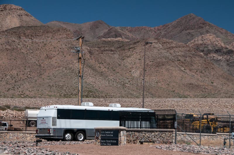 Un autob?s que lleva a inmigrantes llega la estaci?n de la patrulla fronteriza de los E.E.U.U., El Paso Tejas, vivienda temporal/ imagen de archivo libre de regalías Un autob?s que lleva a inmigrantes llega la estaci?n de la patrulla fronteriza de los E.E.U.U., El Paso Tejas, vivienda temporal/ imagen de archivo libre de regalías