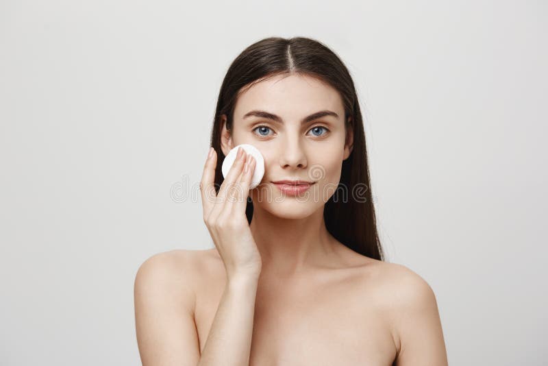 Un autre jour de lutter pour la beauté Tir d'intérieur de beau jeune maquillage européen de décollage de femme avec la protection image libre de droits Un autre jour de lutter pour la beauté Tir d'intérieur de beau jeune maquillage européen de décollage de femme avec la protection image libre de droits