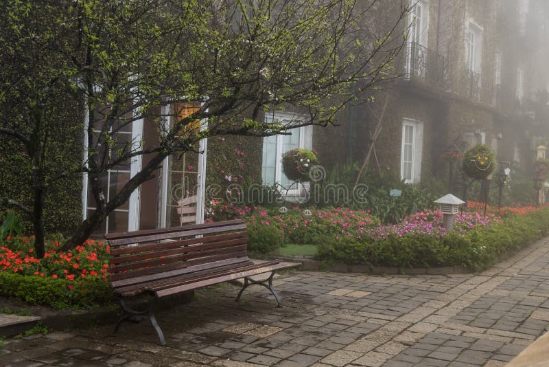 Un banc en bois vide dans le jardin de fleurs photographie stock libre de droits Un banc en bois vide dans le jardin de fleurs photographie stock libre de droits
