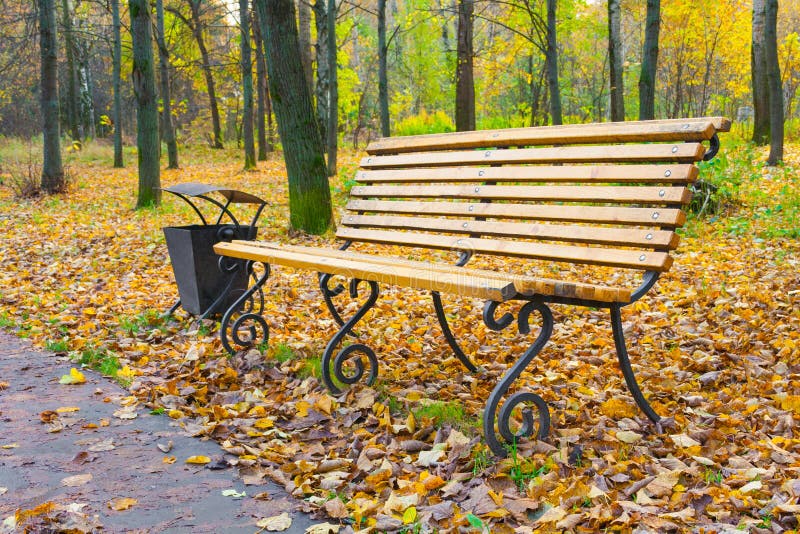 Un banco di legno in un parco di autunno immagini stock Un banco di legno in un parco di autunno immagini stock