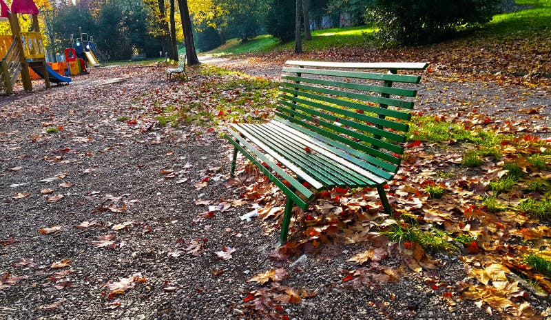 Un banco verde en un parque con las hojas caidas de Florencia en otoño imágenes de archivo libres de regalías Un banco verde en un parque con las hojas caidas de Florencia en otoño imágenes de archivo libres de regalías