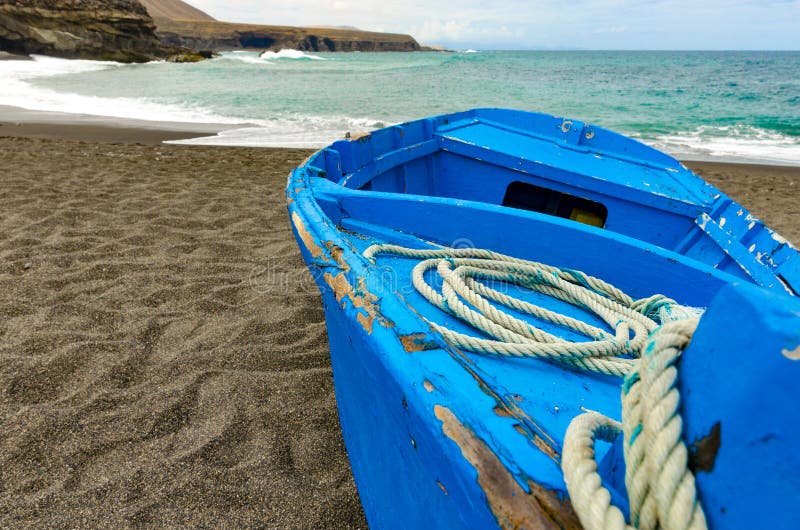 Un barco azul en una playa negra fotografía de archivo libre de regalías Un barco azul en una playa negra fotografía de archivo libre de regalías