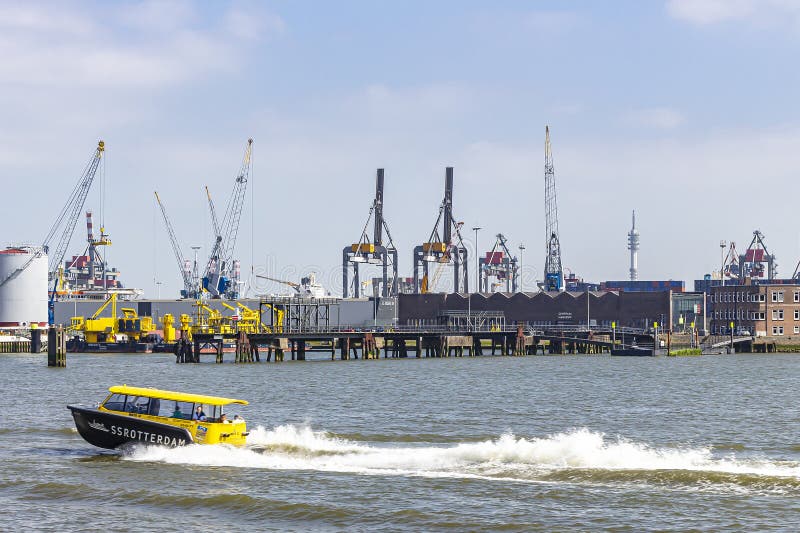 Un barco blando de los SS Rotterdam con en el fondo las grúas en el Waalhaven de Rotterdam transporta a pasajeros hacia adelante foto de archivo libre de regalías Un barco blando de los SS Rotterdam con en el fondo las grúas en el Waalhaven de Rotterdam transporta a pasajeros hacia adelante foto de archivo libre de regalías