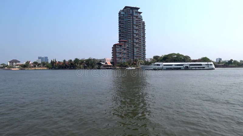 Un barco de la travesía del río pasa delante de un condominio de lujo