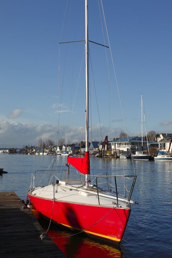 A red sailboat moored in a bayou in Portland Oregon. A red sailboat moored in a bayou in Portland Oregon.