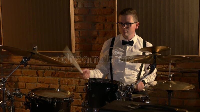 Un batteur masculin joue de la batterie en studio. le groupe musical joue au restaurant.