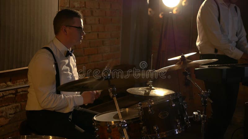 Un batteur masculin joue de la batterie en studio. le groupe musical joue au restaurant.