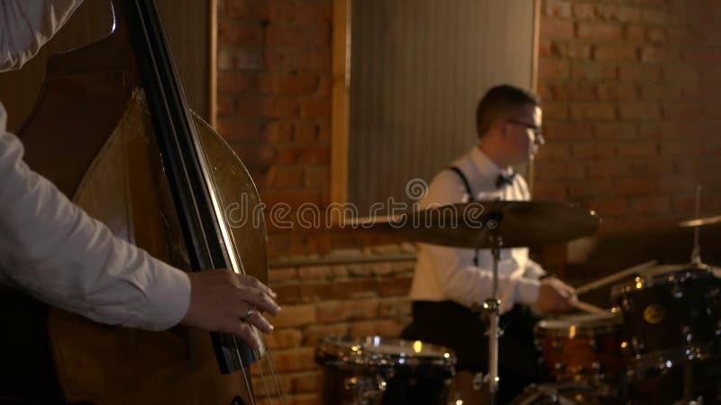 Un batteur masculin joue de la batterie en studio. le groupe musical joue au restaurant.