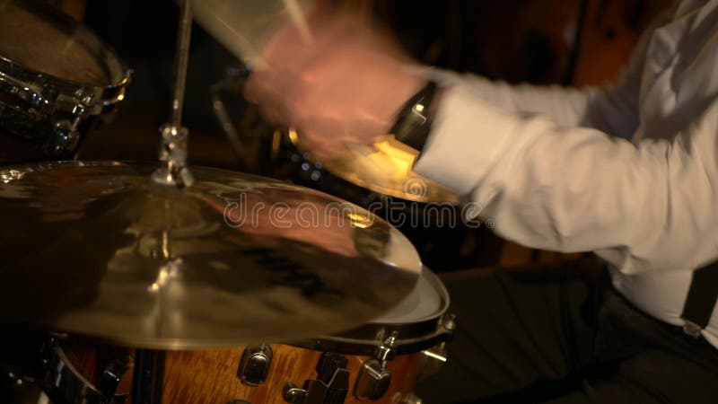 Un batteur masculin joue de la batterie en studio. le groupe musical joue au restaurant.