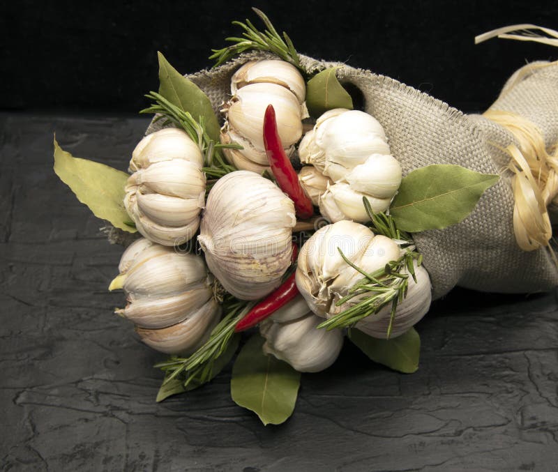 Un beau bouquet de fleurs d'ail frais avec des feuilles de poivron rouge et de la baie. Enveloppé dans les carpettes brutes et fi image stock