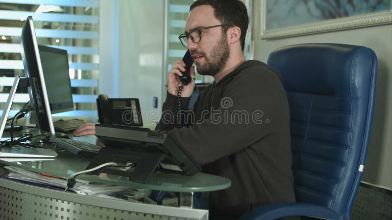 Un bell'operaio in un call center che parla al telefono