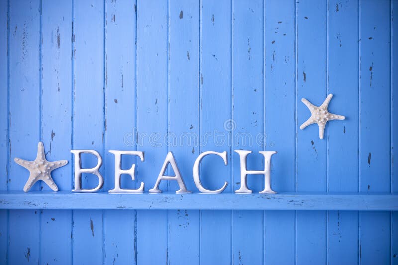 A blue painted rustic wood background that has the word Beach spelled out in letters. With two starfish. Could be a fence or a wall. A blue painted rustic wood background that has the word Beach spelled out in letters. With two starfish. Could be a fence or a wall.