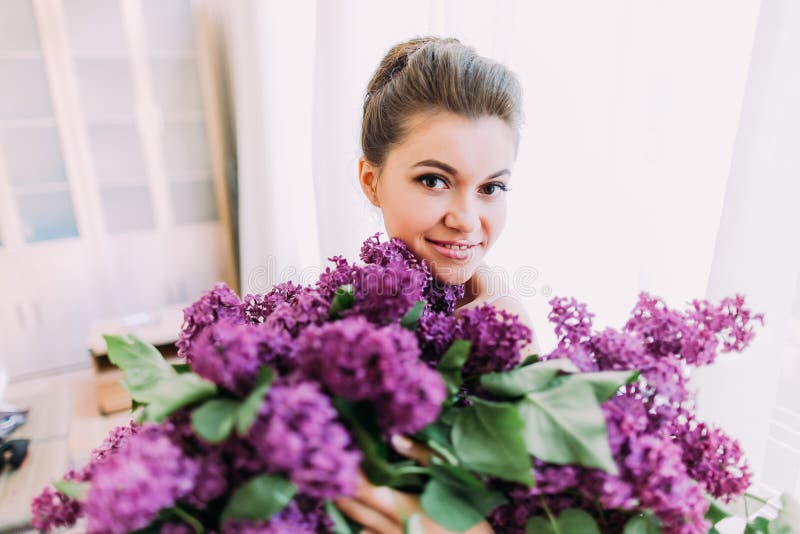 Un bouquet énorme de lilas dans les mains de la jolie jeune mariée de sourire photo libre de droits