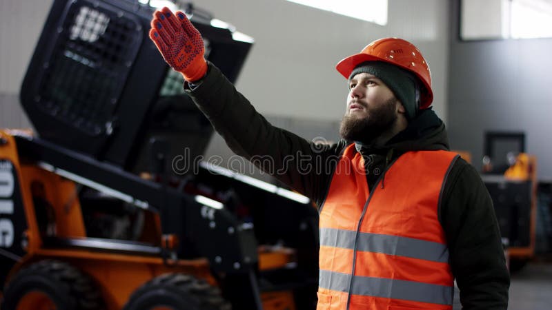 Un buen mec?nico del retrato muestra la aprobaci?n de la muestra, dando los pulgares para arriba el servicio profesional del coch