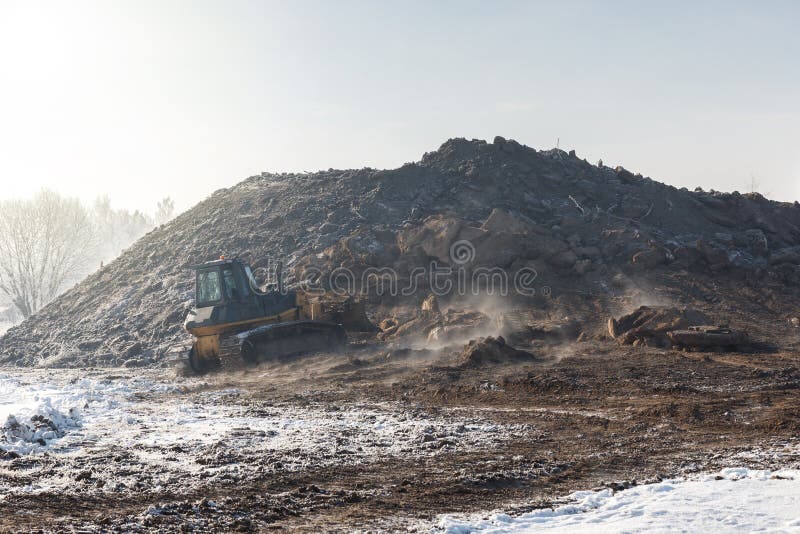 Un bulldozer che funziona nel giorno di inverno fotografia stock Un bulldozer che funziona nel giorno di inverno fotografia stock