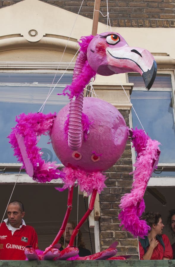 Un burattino gigante del fenicottero che pende da un appartamento immagine stock Un burattino gigante del fenicottero che pende da un appartamento immagine stock