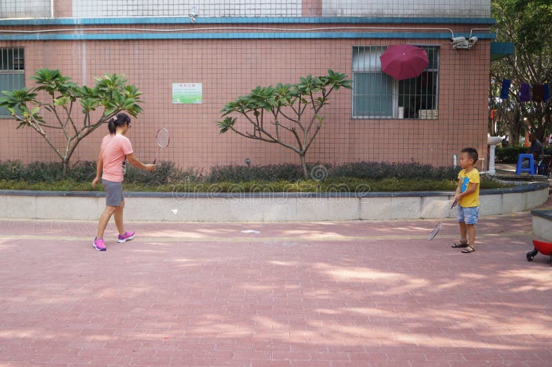 Un bádminton joven del juego de la madre y del hijo imágenes de archivo libres de regalías Un bádminton joven del juego de la madre y del hijo imágenes de archivo libres de regalías