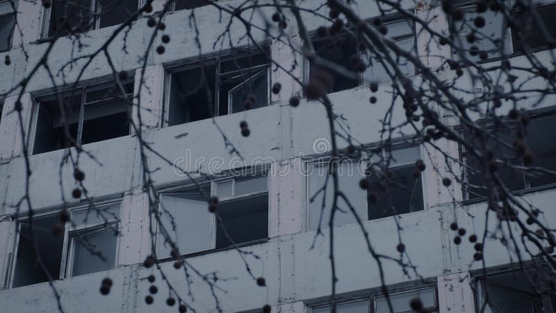 Un bâtiment à plusieurs étages avec des fenêtres cassées en mauvais état. clips vidéos