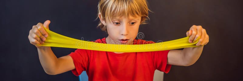 Un băiat care se joacă cu mâna a făcut o jucărie numită slămâie. joacă-te cu copii cu noroi. format lung pentru stocarea și întind stock images