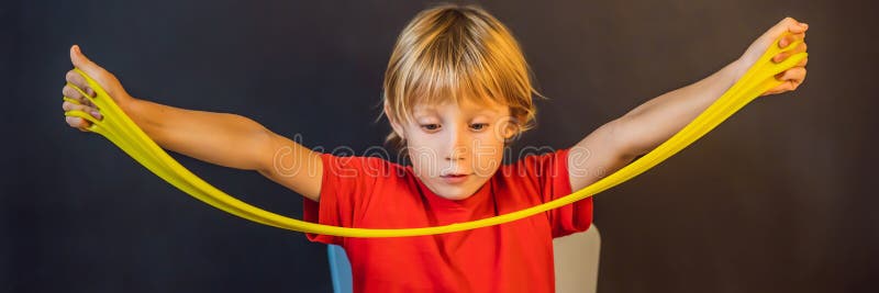 Un băiat care se joacă cu mâna a făcut o jucărie numită slămâie. joacă-te cu copii cu noroi. format lung pentru stocarea și întind stock photo