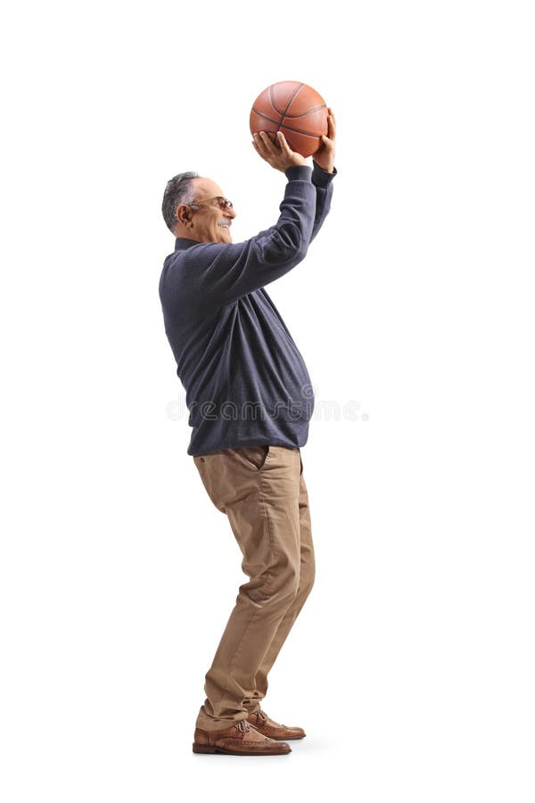 Un bărbat matur care trage un coș de baschet în lungime. royalty free stock photos