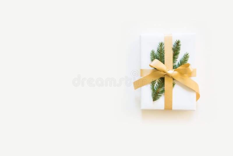 Un cadeau blanc du ` s de nouvelle année avec un ruban d'or et un tre de Noël photos stock Un cadeau blanc du ` s de nouvelle année avec un ruban d'or et un tre de Noël photos stock