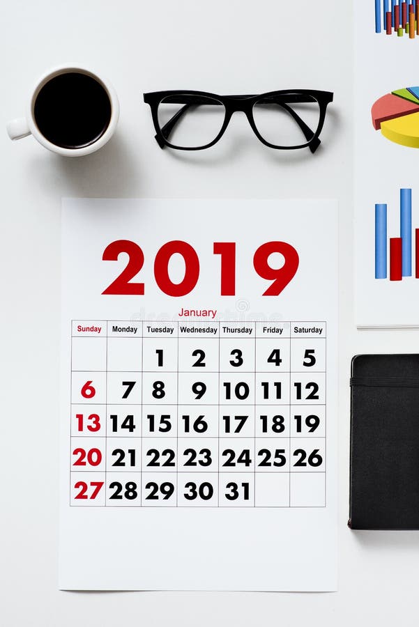 Un calendario di 2019, caffè, occhiali e grafici fotografia stock Un calendario di 2019, caffè, occhiali e grafici fotografia stock