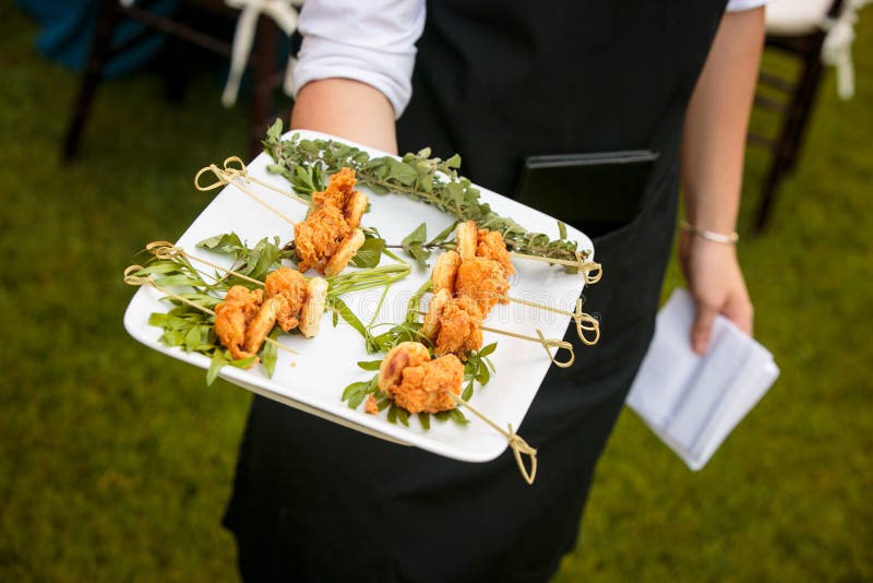 Un camarero que sostiene una placa del mini pollo frito y galletas - serie del abastecimiento de la boda imagen de archivo Un camarero que sostiene una placa del mini pollo frito y galletas - serie del abastecimiento de la boda imagen de archivo