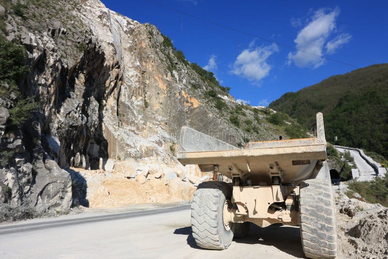 Un cami?n de descargador usado en una mina del m?rmol de Carrara Dum amarillo grande imagen de archivo libre de regalías Un cami?n de descargador usado en una mina del m?rmol de Carrara Dum amarillo grande imagen de archivo libre de regalías