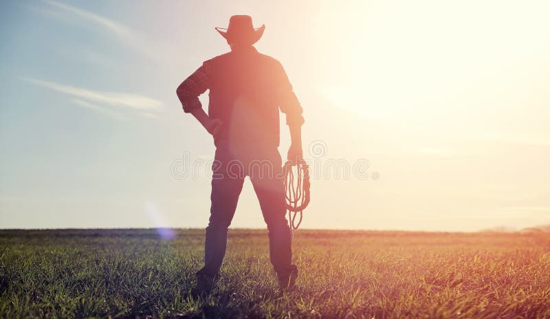 Un cappello da cowboy dell'uomo e un loso nel campo Agricoltore americano in una f fotografia stock libera da diritti Un cappello da cowboy dell'uomo e un loso nel campo Agricoltore americano in una f fotografia stock libera da diritti