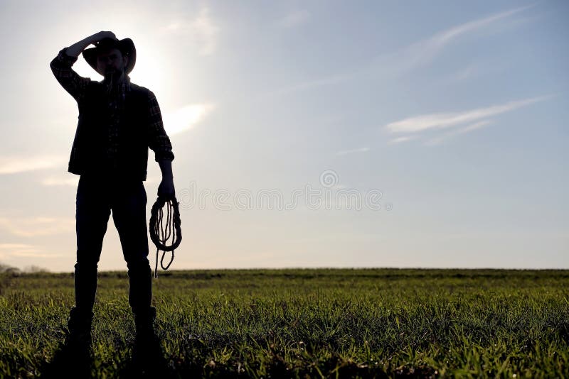 Un cappello da cowboy dell'uomo e un loso nel campo Agricoltore americano in una f fotografie stock libere da diritti Un cappello da cowboy dell'uomo e un loso nel campo Agricoltore americano in una f fotografie stock libere da diritti