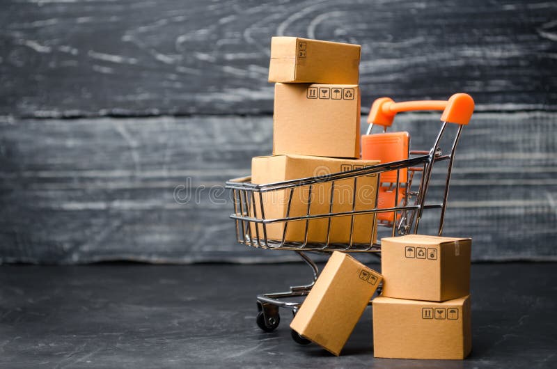 Un carro del supermercado cargado con las cajas de cartón Ventas de mercancías concepto de comercio y negocios, compras en línea
