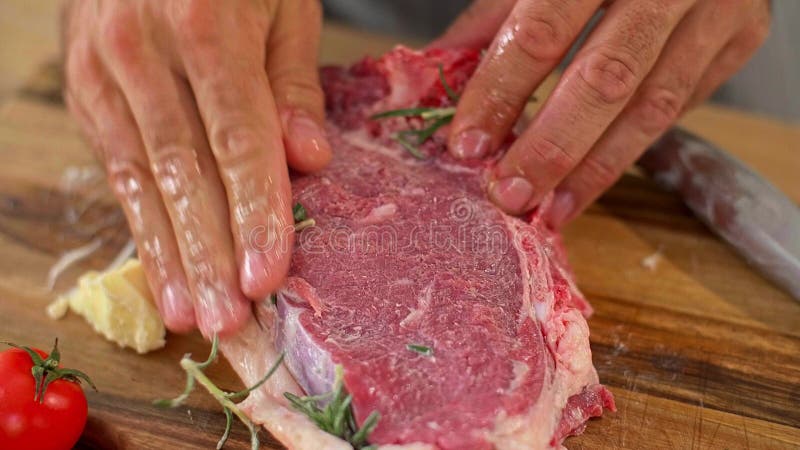 Un cierre de un chef frotando mantequilla en un trozo de carne metrajes