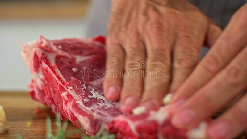 Un cierre de un chef frotando mantequilla en un trozo de carne almacen de metraje de vídeo