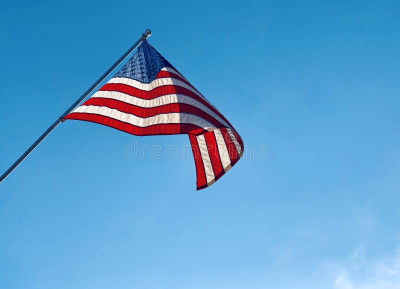 Un cierre de una bandera norteamericana soplando en un asta