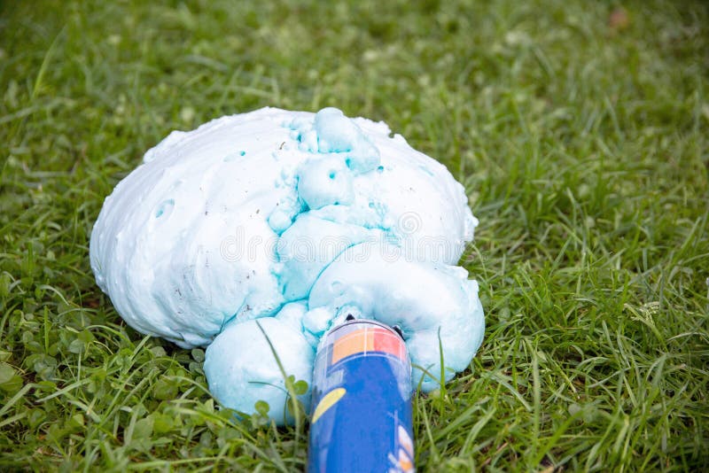 Un cilindro explotado con espuma de construcción sobre la hierba. cierre de defecto de globo foto de archivo