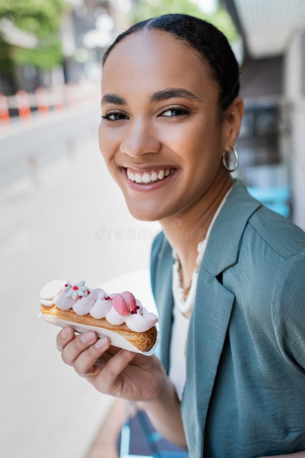 Un cliente joven y bonito que lleva un delicioso eclair fotografía de archivo libre de regalías