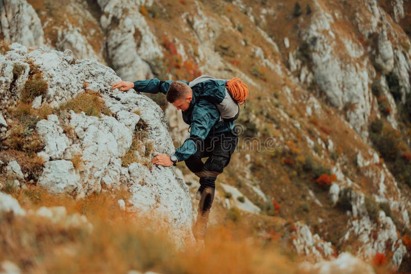 Un climber maschio che si arrampica sulla scogliera di montagna viaggia con l'adrenalina, sport estremo all'aperto. immagine stock libera da diritti