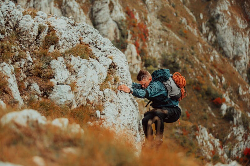 Un climber maschio che si arrampica sulla scogliera di montagna viaggia con l'adrenalina, sport estremo all'aperto. fotografia stock