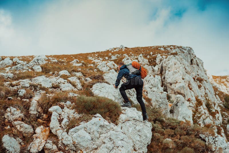 Un climber maschio che si arrampica sulla scogliera di montagna viaggia con l'adrenalina, sport estremo all'aperto. immagini stock libere da diritti