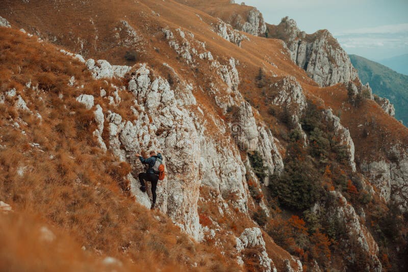 Un climber maschio che si arrampica sulla scogliera di montagna viaggia con l'adrenalina, sport estremo all'aperto. immagini stock