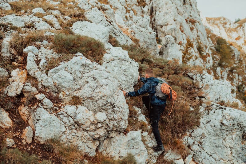 Un climber maschio che si arrampica sulla scogliera di montagna viaggia con l'adrenalina, sport estremo all'aperto. immagini stock libere da diritti