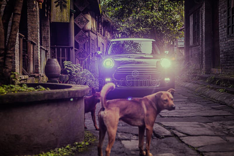 At night, a small black car is driving on a stone road in an ancient Chinese town. At night, a small black car is driving on a stone road in an ancient Chinese town