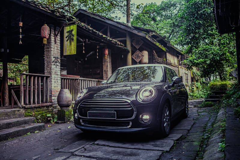 At night, a small black car is driving on a stone road in an ancient Chinese town. At night, a small black car is driving on a stone road in an ancient Chinese town