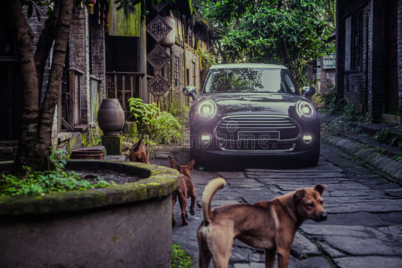 At night, a small black car is driving on a stone road in an ancient Chinese town. At night, a small black car is driving on a stone road in an ancient Chinese town