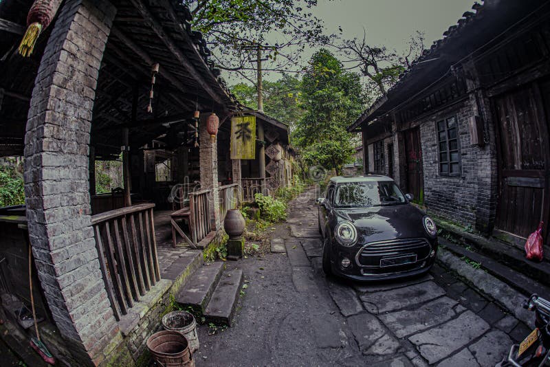 At night, a small black car is driving on a stone road in an ancient Chinese town. At night, a small black car is driving on a stone road in an ancient Chinese town