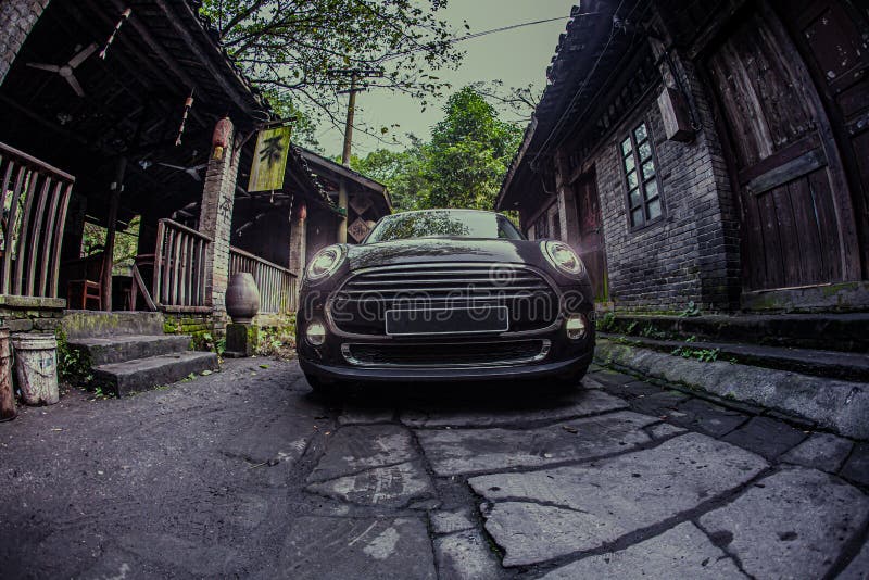 At night, a small black car is driving on a stone road in an ancient Chinese town. At night, a small black car is driving on a stone road in an ancient Chinese town