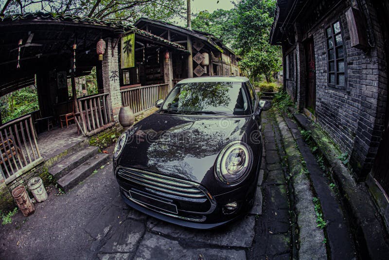 At night, a small black car is driving on a stone road in an ancient Chinese town. At night, a small black car is driving on a stone road in an ancient Chinese town